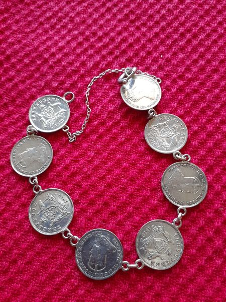 A silver bracelet made from threepenny pieces linked together